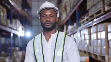 4k Kararlılığın iş konsepti. Afrikalı bir adam güvenle kollarını bir depoda kavuşturdu..