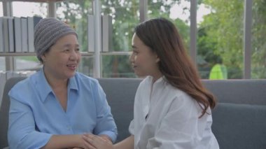 Aile kavramı 4k Kararlılığı. Anne ve kızı oturma odasında birbirlerinin kafalarına dokunuyorlar..