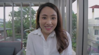 Tatil konsepti 4k Çözünürlük. Asyalı bir kadın evinde röportaj veriyor..