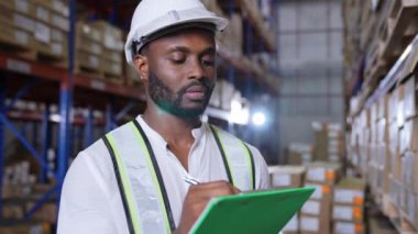 4k Kararlılığın iş konsepti. Afrikalı adam depoda malları kontrol ediyor..