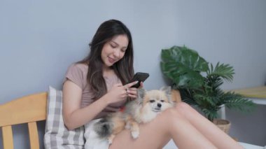 Tatil konsepti 4k Çözünürlük. Asyalı kızlar yatak odasında cep telefonu oynuyorlar..