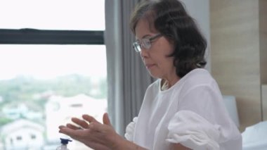 4k Çözünürlük 'ün güzellik konsepti. Yatak odasına krem süren yaşlı bir kadın. Cilt bakımı Kırışıklıkları azaltır.