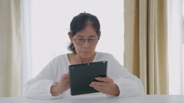 假日4K解像度的概念 亚洲老年妇女对科技感兴趣 她们在家里用平板电脑 — 图库视频影像
