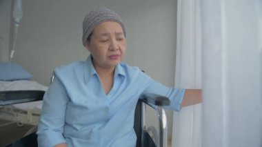 Sağlık konsepti 4k Çözünürlük. Yaşlı bir Asyalı kadın hastanede akrabalarının ziyaretini bekliyor. Yalnızlığın içinde yalnız olmak.