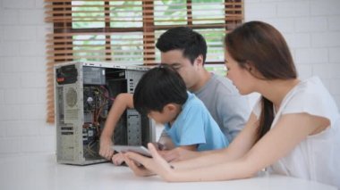 Aile kavramı 4k Kararlılığı. Ebeveynler çocuklarını bilgisayar tamir etmeyi öğrenmeleri için teşvik ediyorlar. Çocuk eğitimi ve öğrenimi.
