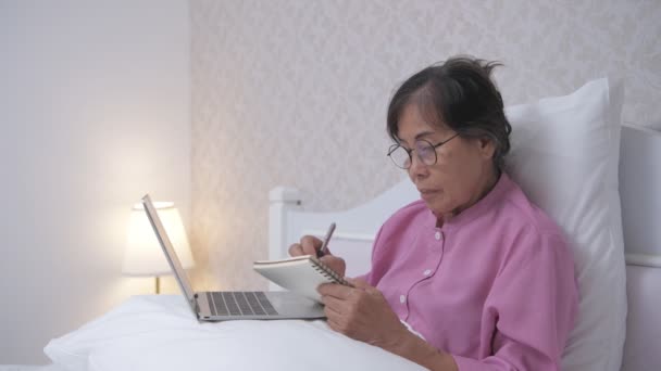 假日4K解像度的概念 亚洲老太太在家里用电脑干活 学习如何为老年人使用技术 — 图库视频影像