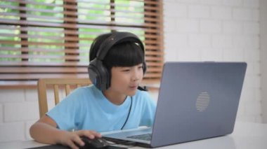 Teknoloji konsepti 4k Çözünürlük. Asyalı çocuk evde bilgisayar oyunu oynuyor. Yarışmada yenilgi.