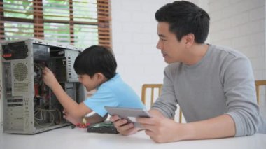 Aile kavramı 4k Kararlılığı. Ebeveynler çocuklarını bilgisayar tamir etmeyi öğrenmeleri için teşvik ediyorlar. Çocuk eğitimi ve öğrenimi.
