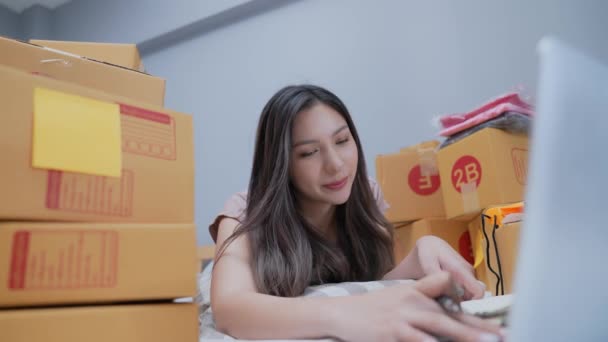 4K解像度のビジネスコンセプト アジアの女性は自宅で顧客の注文をチェックします お客様への商品のお届け — ストック動画