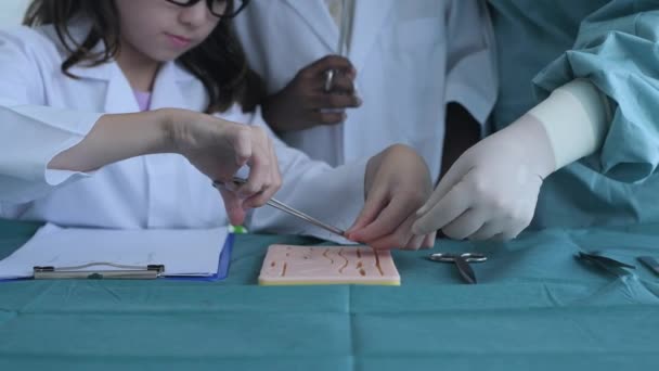 4K解像度の教育概念 教室で縫合傷を練習している医学生 インターンの先生 訓練シミュレーション — ストック動画