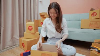 4k Kararlılığın iş konsepti. Asyalı kadın evdeki kutularda ürünleri paketliyor..