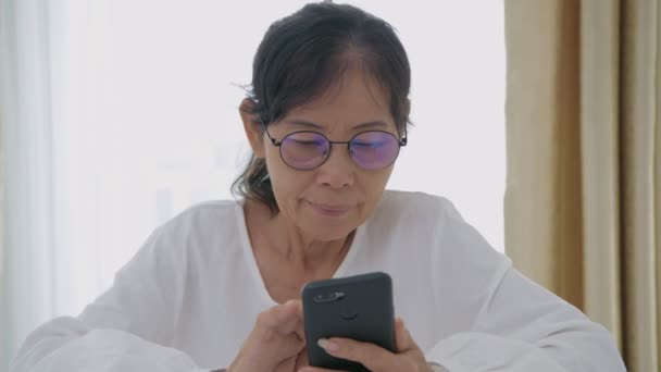 假日4K解像度的概念 一位年迈的亚洲女人对科技和在家里使用手机感兴趣 — 图库视频影像