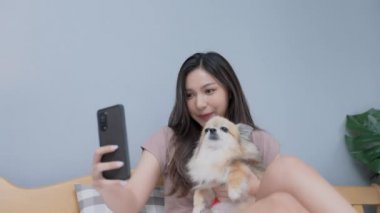 Tatil konsepti 4k Çözünürlük. Asyalı kızlar yatak odasında cep telefonlarıyla oynuyorlar. Akıllı bir telefonla fotoğraf çek..