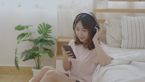 假日4K解像度的概念 亚洲女人在卧室里听音乐 假日娱乐活动 — 图库视频影像