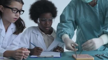 Eğitim konsepti 4k Kararlılık. Tıp fakültesi öğrencileri sınıfta dikiş pratiği yapıyor. Stajyer doktor. eğitim simülasyonu.