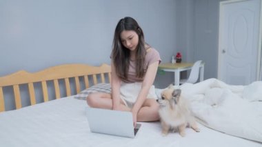 Tatil konsepti 4k Çözünürlük. Yatak odasında bilgisayarla çalışan Asyalı kızlar..