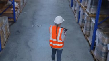 4k Kararlılığın iş konsepti. Bir çalışan depoda tabletle malları kontrol ediyor..