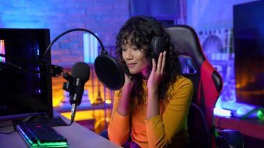 Yayınlanan 4k Çözünürlük kavramı. Stüdyoda şarkı söyleyen Asyalı bir kadın. canlı yayın.