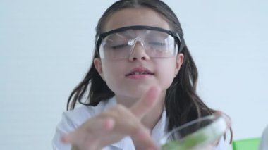 Eğitim konsepti 4k Kararlılık. Genç bir kız laboratuarda yapılan bir deneyi anlatıyor..