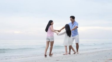 Tatil konsepti 4k Çözünürlük. Asyalı ebeveynler ve kızlar sahilde eğleniyorlar. Yaz tatili.