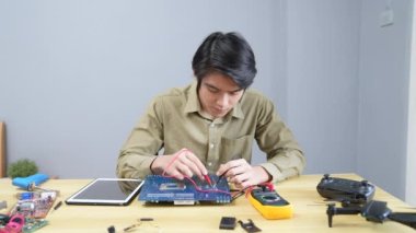 Teknoloji konsepti 4k Çözünürlük. Asyalı adam evdeki elektrik devrelerini kontrol ediyor. bilgisayar onarımı.