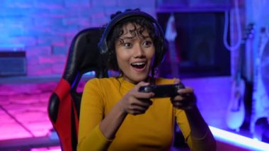 Tatil konsepti 4k Çözünürlük. Asyalı kadın oturma odasında oyun oynuyor. Online oyun oynamanın eğlencesi.