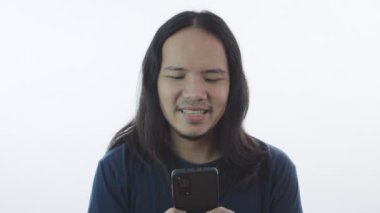 Tatil konsepti 4k Çözünürlük. Asyalı genç adam beyaz arka planda cep telefonu çalıyor. resim arkaplandan izole edildi.