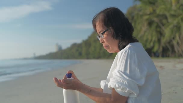 Çözünürlük Güzellik Konsepti Yaşlı Bir Kadın Plajda Güneş Kremi Sürüyor — Stok video