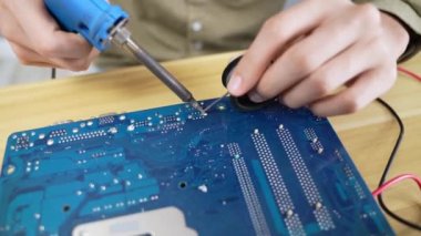 Teknoloji konsepti 4k Çözünürlük. Evdeki elektronik devreleri bağlayan Asyalı bir adam. bilgisayar onarımı.