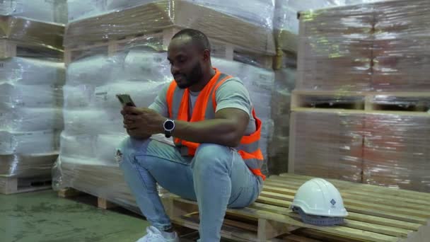 4K解像度のビジネスコンセプト 従業員は倉庫で働くことから休憩しています 携帯電話を — ストック動画