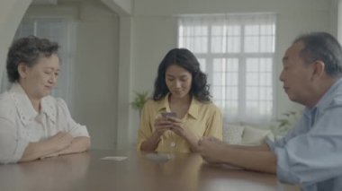 Tatil konsepti 4k Çözünürlük. Asyalı aileler evde oyun oynarken sırayla kart atıyorlar. Aile kumar oyunları.