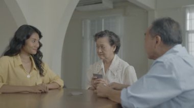 Tatil konsepti 4k Çözünürlük. Asyalı aileler evde oyun oynarken sırayla kart atıyorlar. Aile kumar oyunları.