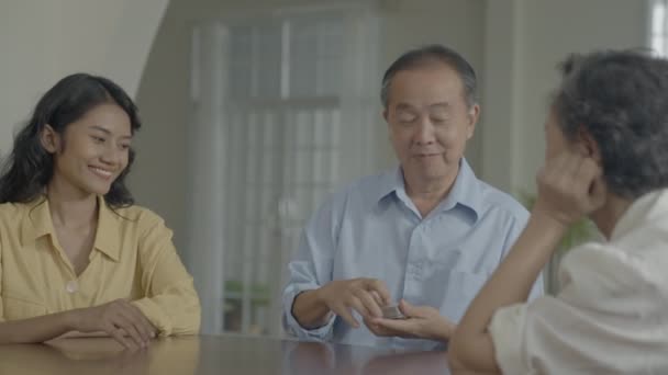 假日4K解像度的概念 亚洲家庭在家里玩游戏时 轮流把卡片扔在桌上 家庭赌博游戏 — 图库视频影像