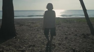 Seyahat konsepti 4k Çözünürlük. Kumsalda yürüyen yaşlı bir kadın..