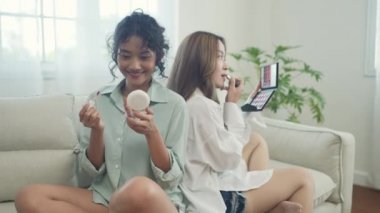4k Çözünürlük 'ün güzellik konsepti. Asyalı kızlar oturma odasında birlikte makyaj yapıyorlar..