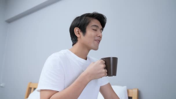대한민국의 보물제 지정됐다 아시아 남자는 침실에서 행복하게 커피를 마십니다 — 비디오