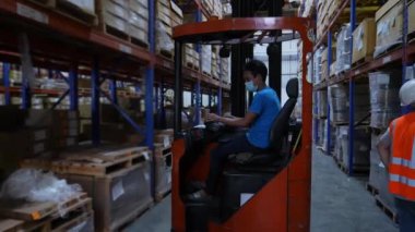 4k Kararlılığın iş konsepti. Bir çalışan depoda forklift kullanıyor..