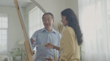 Sanatçı konsepti 4k Çözünürlük. Galeride Asyalı bir kadın çalışmalarını sunuyor. Sanatçı iş yaratıyor. Boş zaman aktiviteleri ve hobileri.