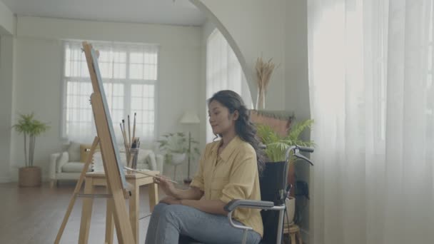4K解像度のアーティストコンセプト 居間にはアジア系の女性が描かれている アーティストが作品を作っています 障害者は趣味を作っています — ストック動画