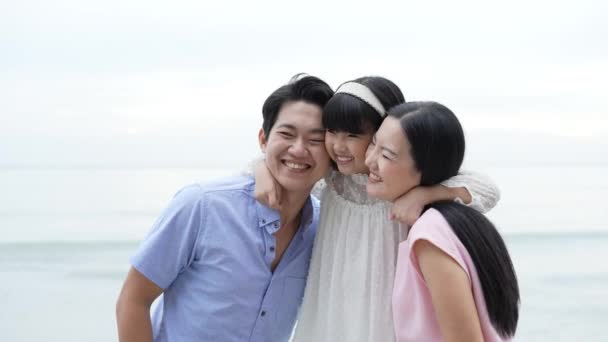 4K解像度の休日の概念 娘はビーチでお母さんとお父さんの頬にキスする 若いアジアの女の子は喜んで笑顔 親子関係 — ストック動画