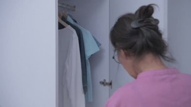 Tatil konsepti 4k Çözünürlük. Elbiselerini seçen Asyalı yaşlı bir kadın..