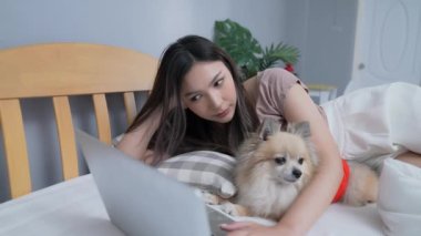 Tatil konsepti 4k Çözünürlük. Yatak odasında bilgisayarla çalışan Asyalı kızlar..