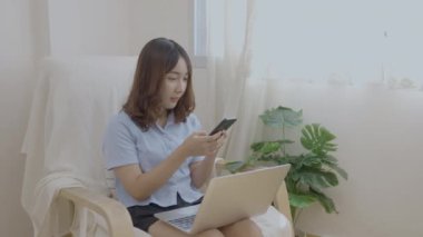 Tatil konsepti 4k Çözünürlük. Asyalı kız oturma odasında bilgisayarla çalışıyor..
