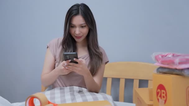 4K解像度のビジネスコンセプト 携帯電話を使ってお客様とつながるアジアの女性 — ストック動画