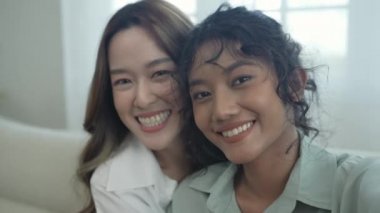 4k Çözünürlük ev arkadaşı konsepti. Asyalı kadınlar oturma odasında resim çekiyorlar..
