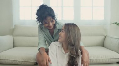 Tatil konsepti 4k Çözünürlük. Oturma odasında kameraya bakan Asyalı kadın. Genç kadınların ortak bir lezbiyen ilişkisi var..