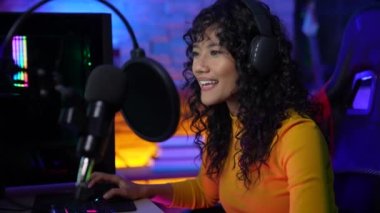 Tatil konsepti 4k Çözünürlük. Asyalı kadınlar çevrimiçi radyo programı sunuyorlar. Disk jokeyi. DJ mikrofonla konuşuyor..