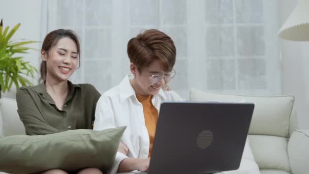 假日4K解像度的概念 亚洲妇女在客厅里一起玩笔记本电脑 年轻女性之间有一种相互的同性恋关系 — 图库视频影像