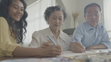 Sanatçı konsepti 4k Çözünürlük. Asyalı aileler oturma odasında bir araya geliyorlar. Sanatçı iş yaratıyor. Boş zaman aktiviteleri ve hobileri.