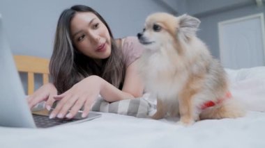 Tatil konsepti 4k Çözünürlük. Yatak odasında bilgisayarla çalışan Asyalı kızlar..